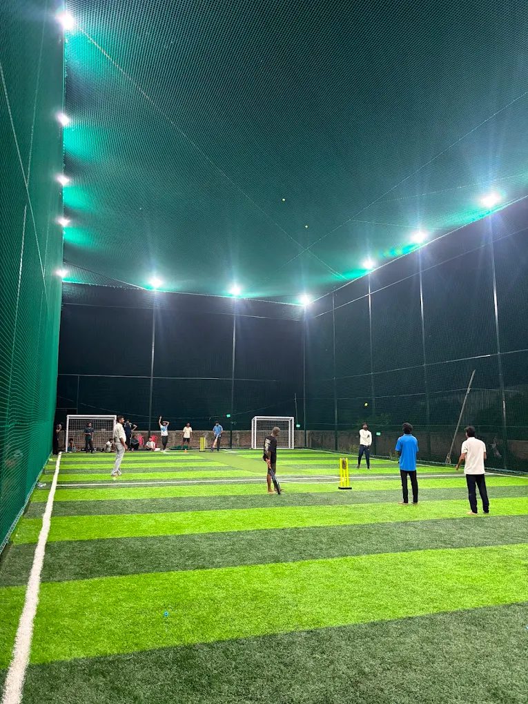 Cricket match in progress under floodlights at The Turf X